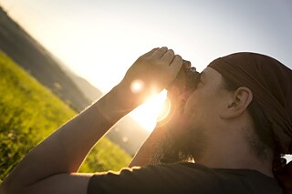 Mann fotografiert im Sonnenlicht in der Natur