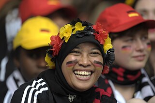 Frau mit Hijab und Deutschland-Fanartikeln bei einem Fussballspiel