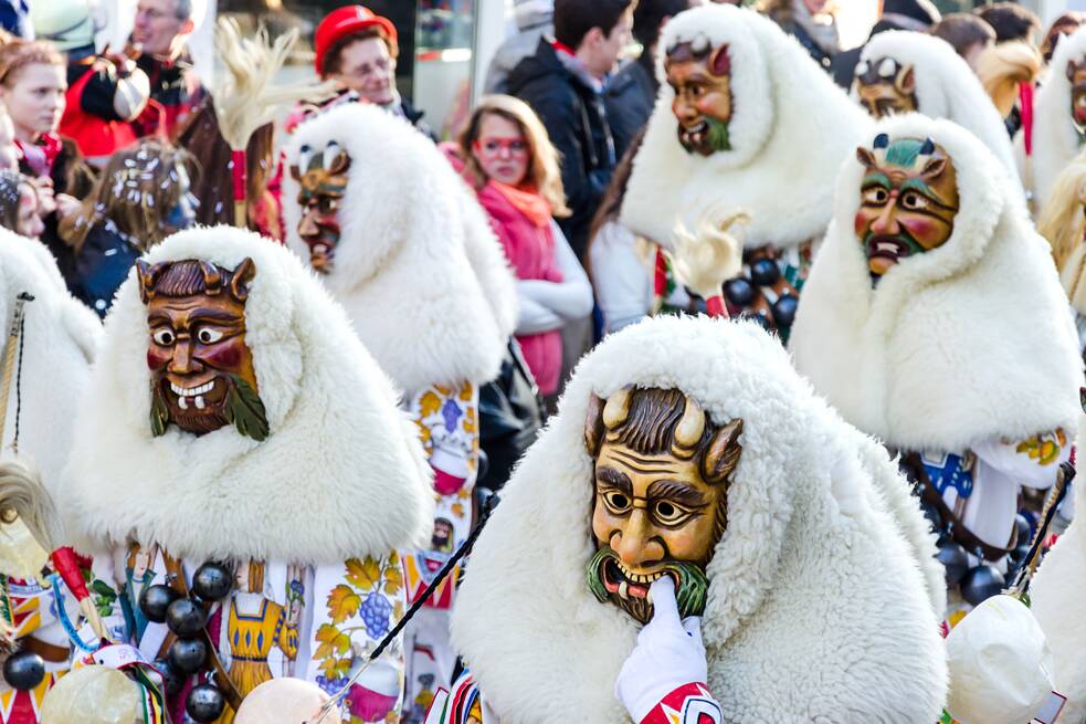 Karnevalsumzug, mit schaurigen Masken verkleidete Personen