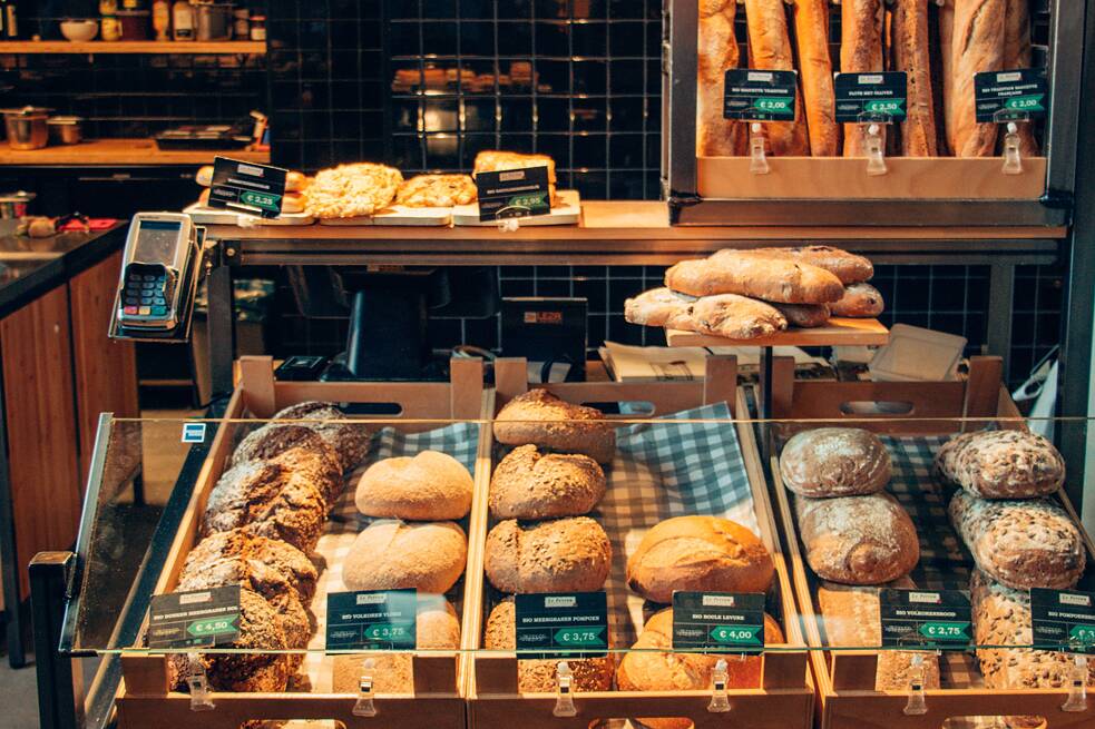 Auslage einer Bäckerei mit Baguette, Brötchen und Kuchen