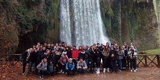 Schülergruppe vor einem Wasserfall