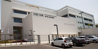 Seitliche Ansicht des Gebäudes mit Parkplatz und drei parkenden Autos