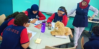 Schüler und Schülerinnen beim Unterricht an einem Gruppentisch