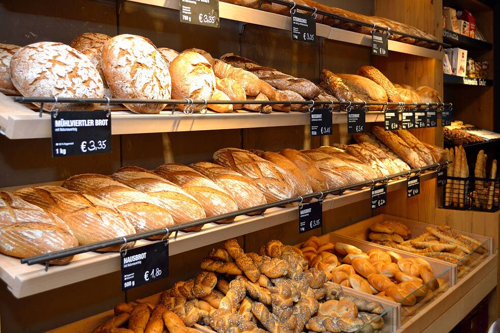 Verschiedene Brote und Brötchen mit Preisschildern in einer deutschsprachigen Bäckerei