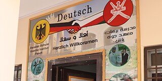 Tür verziert mit deutschen Begriffen, z.B. "Herzlich Willkommen" und einer deutschen Flagge