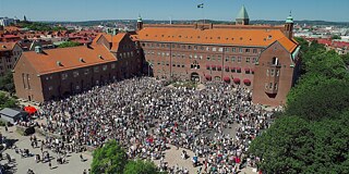 Gebäude von außen mit Schülergruppe auf dem Schulhof
