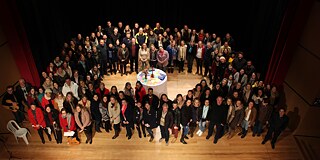 Gruppenfoto der Lehrkräfte in der Aula, von oben fotografiert