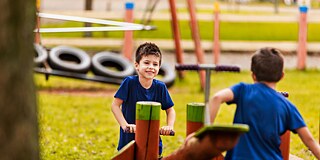 Zwei Schüler spielen auf dem Spielplatz und lachen