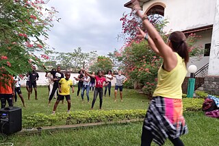 Schülerinnen und Schüler machen Zumba. Die Lehrerin ist im Vordergrund.