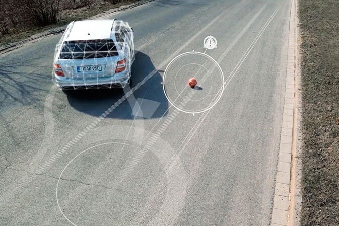 Ein Auto weicht einem Ball auf der Fahrbahn aus