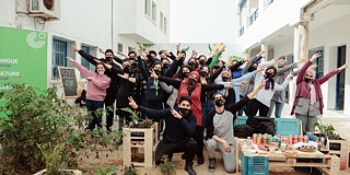 Gruppenbild neben einem Banner des Goethe-Instituts