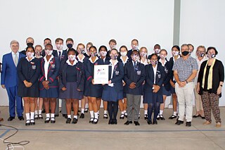 Gruppenfoto mit bunten Mund-Nase-Masken vor einer weißen Wand
