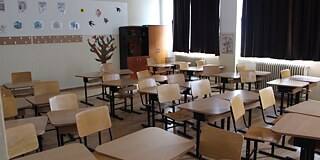Leeres Klassenzimmer mit Holzstühlen und Holztischen