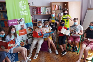 Schülerinnen und Schüler sitzen zusammen in der Leseecke