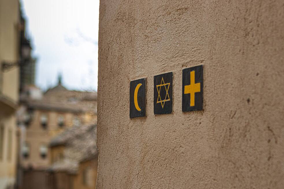 Mehrere religiöse Symbole an einer Wand