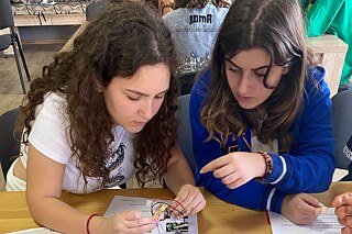 Zwei Schülerinnen an einem Tisch bei einem Workshop