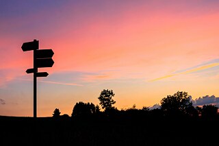 Wegweiser vor einem Sonnenuntergang