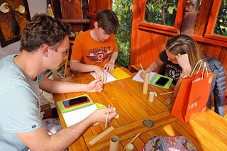 Kinder sitzen zusammen an einem Tisch und schreiben