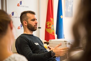 Männlicher Teilnehmer im Gespräch, von der Seite fotografiert