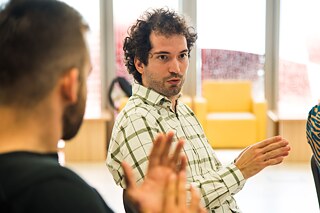 Männlicher Teilnehmer mit kariertem Hemd im Gespräch