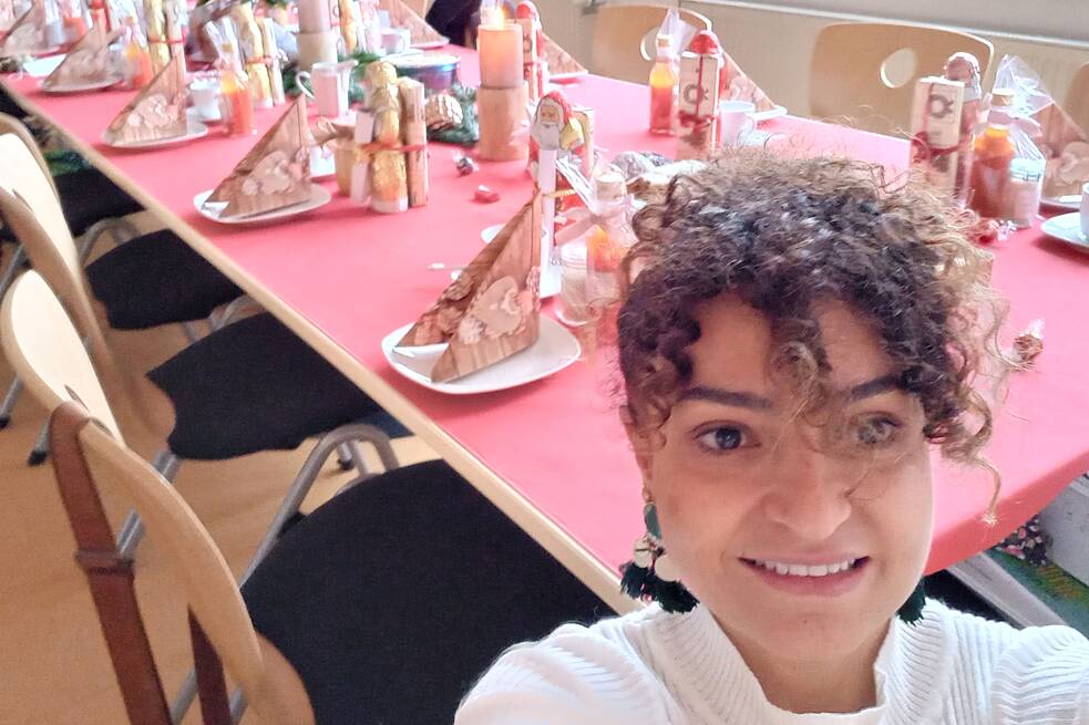 Frau macht ein Selfie, im Hintergrund ein festlich gedeckter Tisch