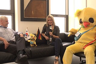 Gemeinsam für die Zukunft – Runde 2! © Goethe-Institut Korea/Heidi Storandt Zwei Personen und ein Küken-Maskottchen sitzen auf drei Sesseln und führen ein Interview