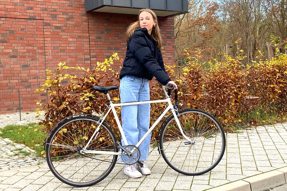 Linn (15 Jahre): Mit dem Fahrrad vor einer Hecke