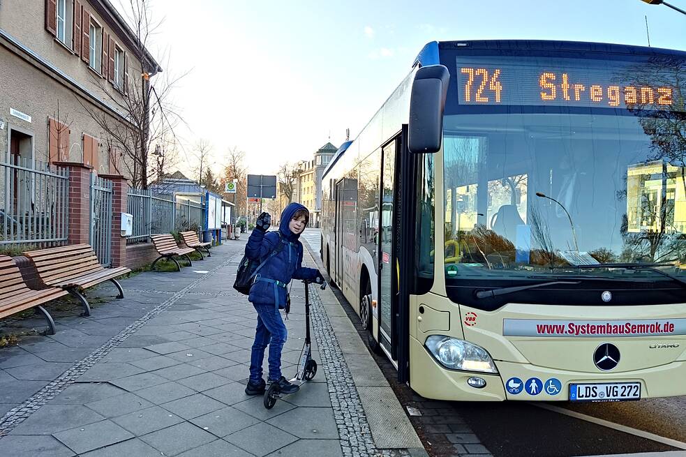 Lunes mit seinem Roller beim Einstieg in den Bus