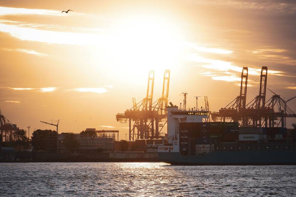 Sonnenuntergang an der Elbe und Blick auf mehrere Container und Krane