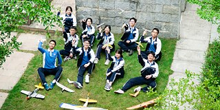 Schülerinnen und Schüler der Shenzhen Second Foreign Languages School mit Modellflugzeugen