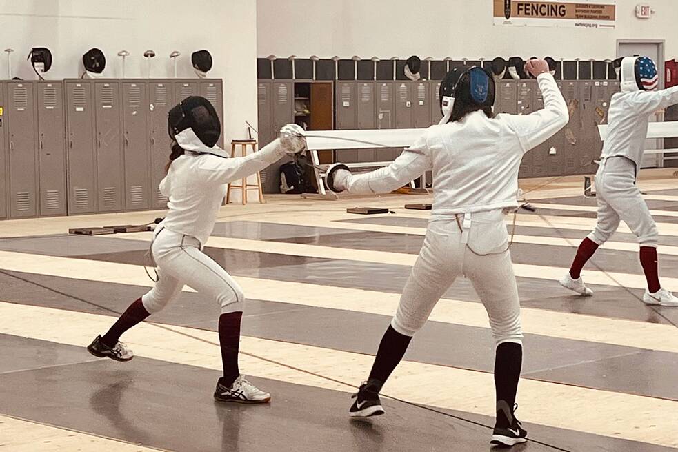 Zwei Personen in weißer Fechtkleidung beim Training