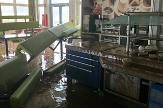 Zerstörter Restaurantbereich voller Wasser und Schlamm