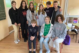 Gruppenfoto der Lernenden in zwei Reihen in einem Klassenzimmer