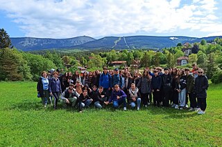 Gruppenfoto auf einer Wiese vor einem Gebirge