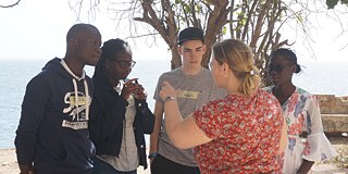 Schulradioprojekt in Senegal – Laboradio wird ins Leben gerufen Goethe-Institut Senegal Frau in rotem Oberteil spricht mit Schülern