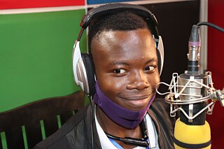 Ein Jugendlicher mit Kopfhörern am Mikrophon