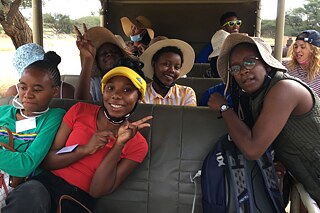 Mehrere Schülerinnen und Schüler sitzen zusammen in einem Bus und lachen