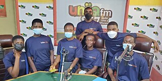 Schüler in blauen T-Shirts und OP-Masken im Studio