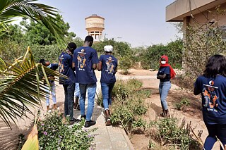Mehrere Schüler und Schülerinnen laufen durch einen Garten