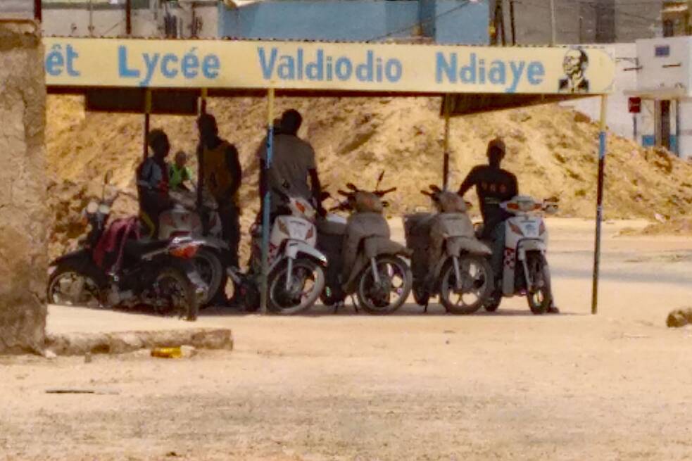 Taxi-Motorräder in Kaolack stehen im Schatten.