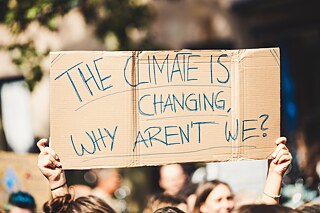 Demontstrationsplakat auf Pappkarton mit der Aufschrift: „The Climate ist changing, why aren't we?“