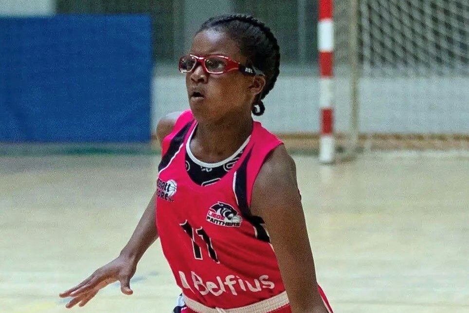 Mädchen mit rotem Trikot mit der Nummer 11 und roter Sportbrille auf dem Spielfeld