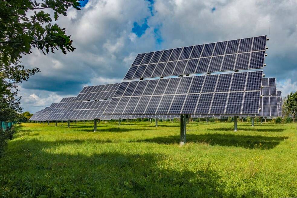 Auf einer Wiese stehen große Solarpanele.