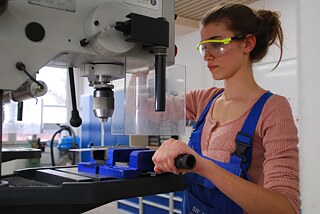 Frau mit Schutzbrille, von der Seite fotografiert