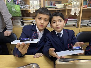 Schüler beim Robotikkurs Zwei junge Schüler beim Robotikkurs präsentieren ihre Modelle