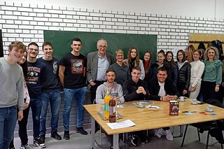Eine Gruppe Schüler*innen und Lehrende in einem Klassenzimmer