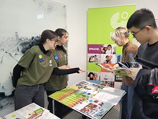 Schülerinnen und Schüler tauschen sich an Infostand aus