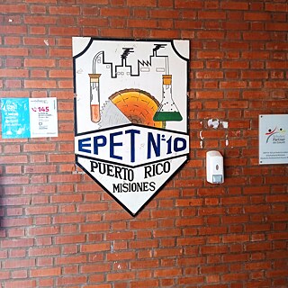 Logo der EPET N° 10 Dr. Luis Federico an Schulmauer, daneben PASCH-Plakette