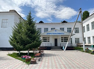 Schulgebäude mit Bäumen und blauem Himmel 
