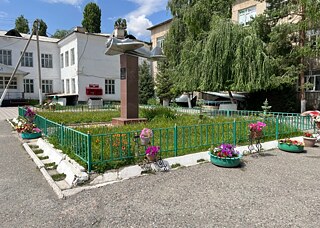 Grünfläche mit Blumenbepflanzungen und Flugzeugskulptur